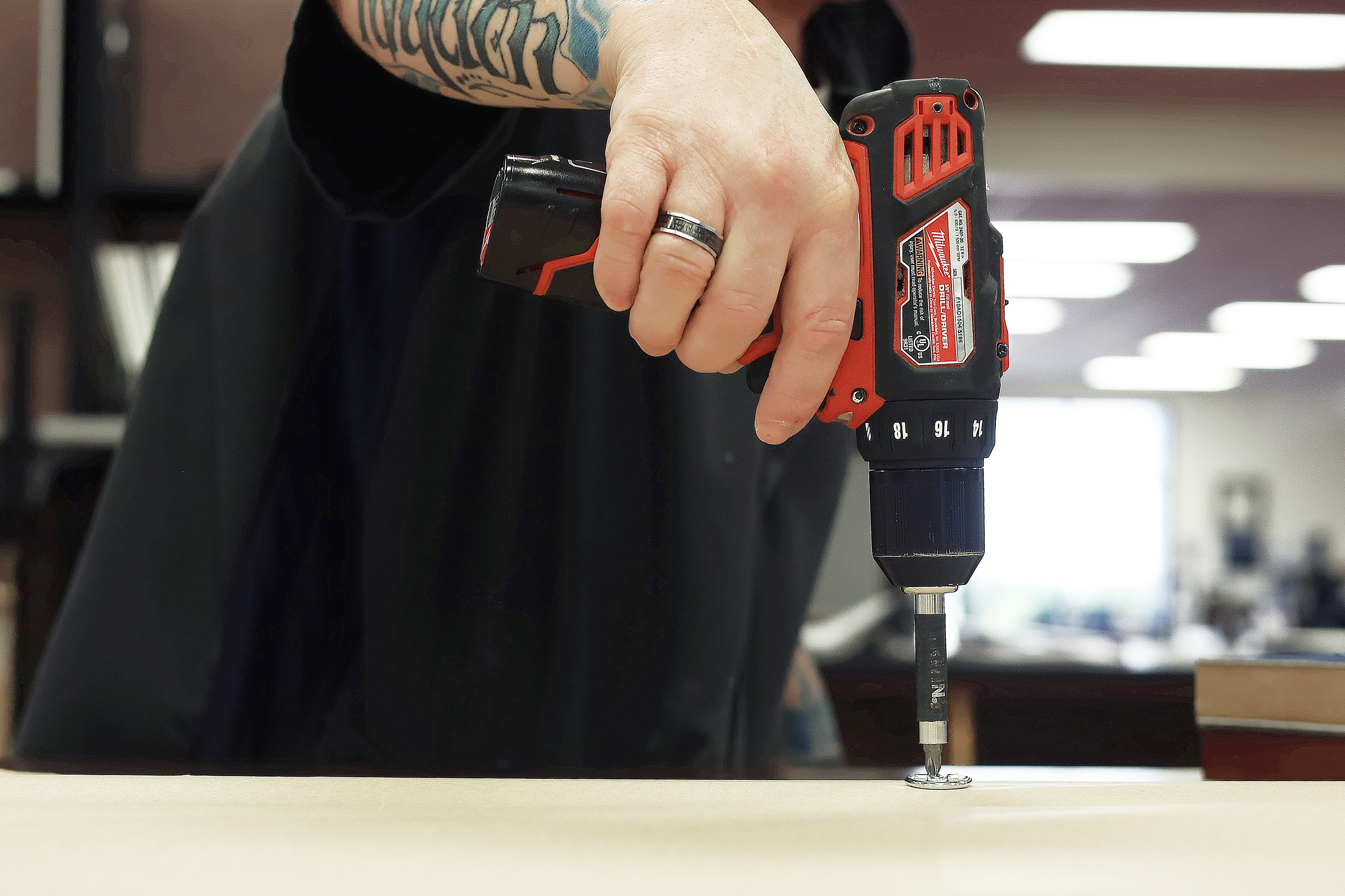 Inmate Working in Frame Shop Drilling Hooks on a Frame