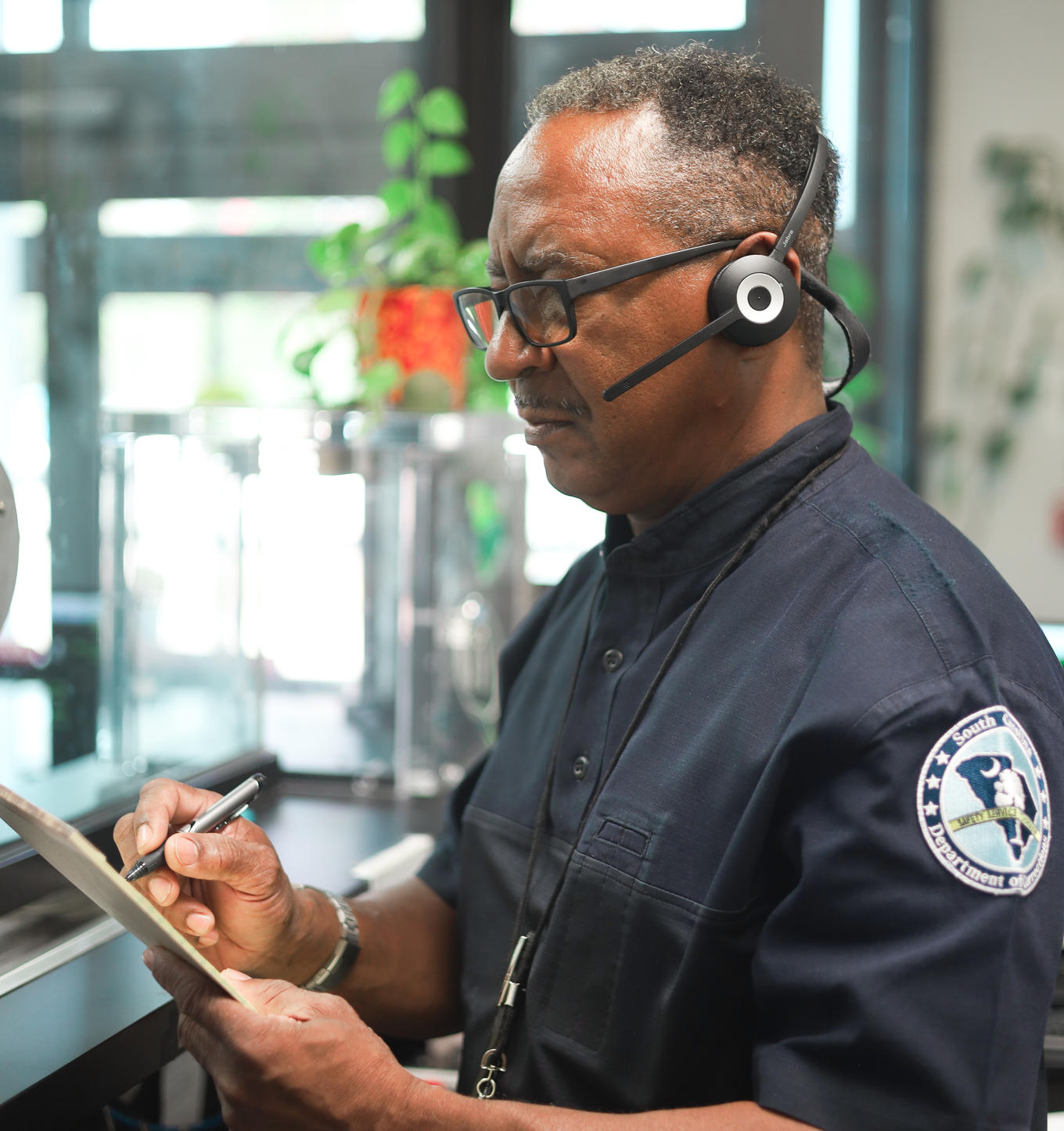 Officer on phone headsets writing notes